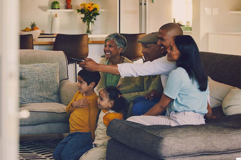 Generations of a family on a couch watching tv together