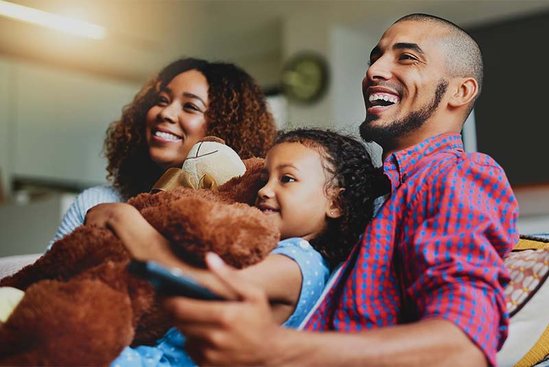 Family on couch with remote control